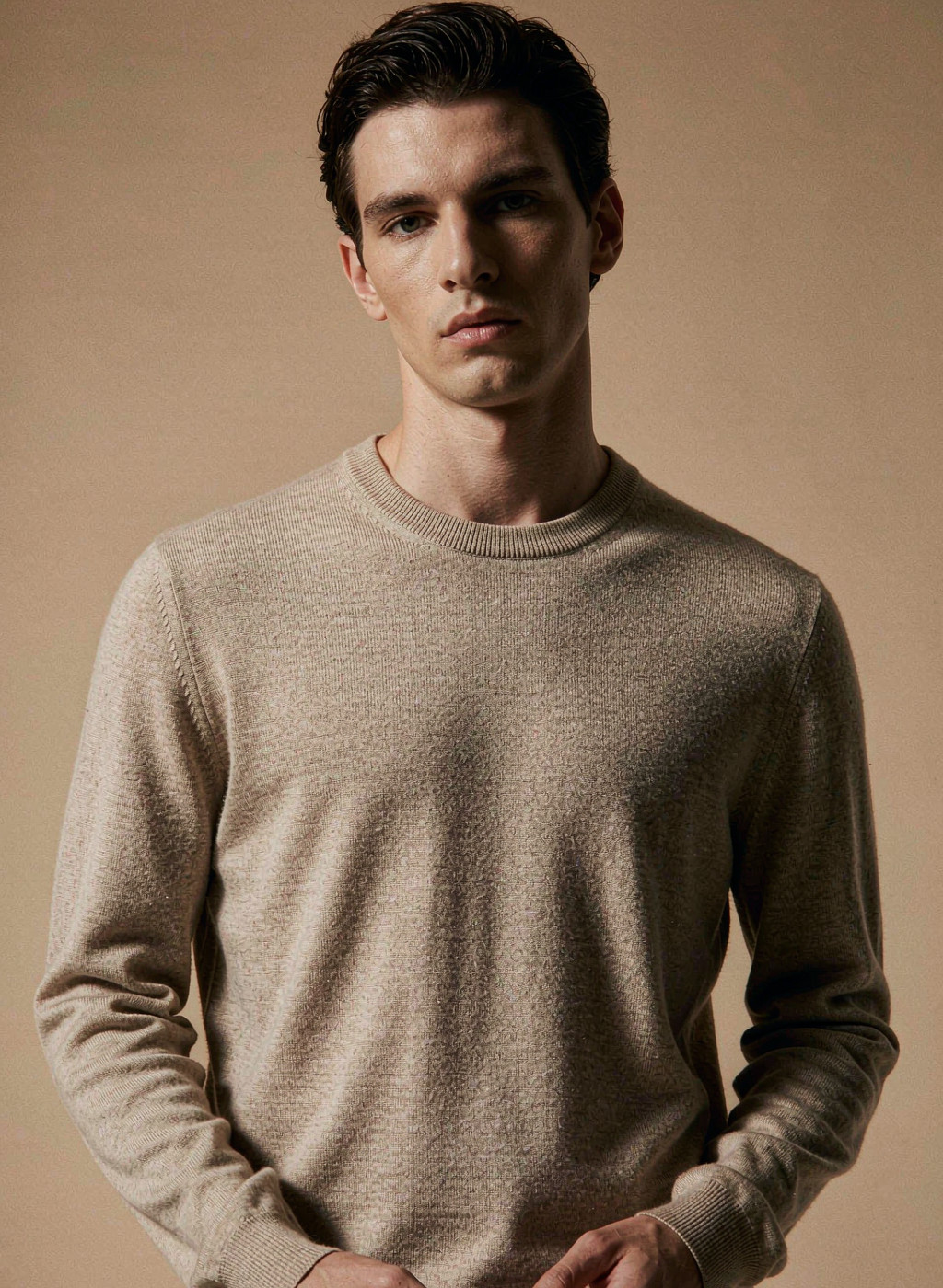 Model wearing an oatmeal merino sweater, knitwear category